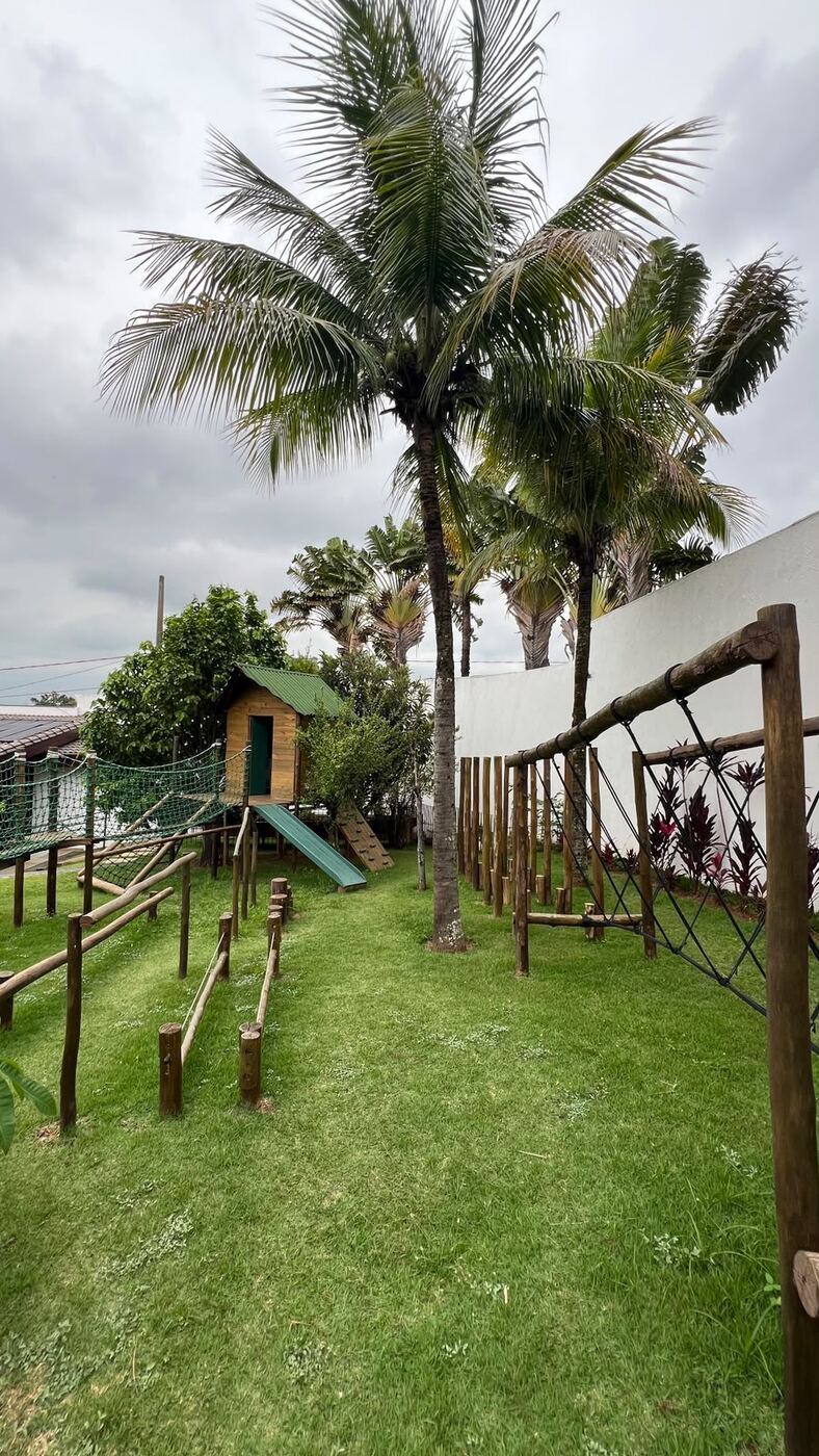 Playground com escorregador e balanço entre coqueiros